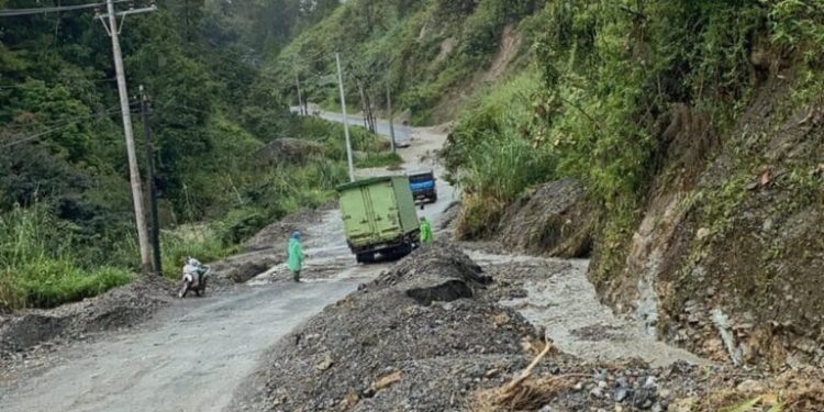 Ruas jalan nasional yang rusak akibat longsor dan tidak adanya saluran air di Aie Dingin.