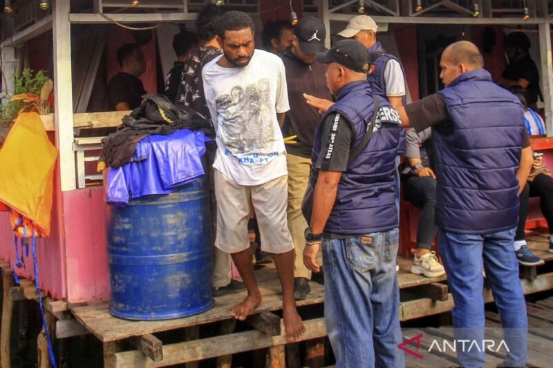 Personel Ditresnarkoba Polda Papua mengamankan tersangka saat penggerebekan narkoba di Kampung Vietnam, Jayapura. (Foto: ANTARA FOTO)